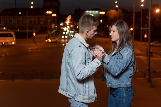 Foto jovem casal apaixonado dançando no fundo da cidade à noite