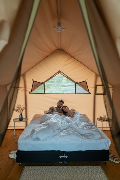 Foto jovem casal apaixonado descansando na cama sob um cobertor branco