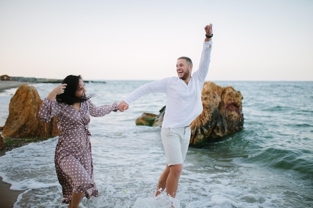 Jovem casal apaixonado Homem e mulher atraentes desfrutando de uma noite romântica na praia assistindo o pôr do sol