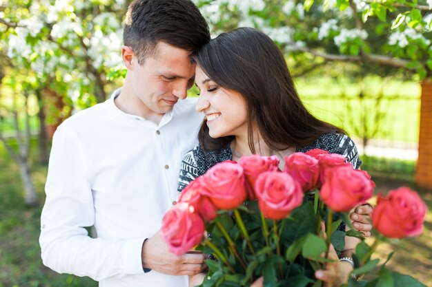 Foto jovem casal apaixonado, mulher segurando flores, feliz e apreciar a bela natureza