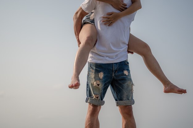 Jovem casal apaixonado na praia, férias de verão. menina alegre no jovem namorado se divertindo no verão