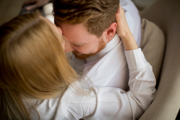 Jovem casal apaixonado no sofá