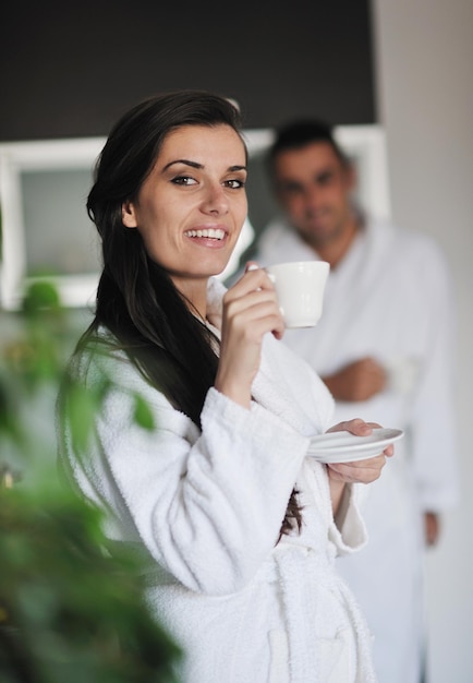 Jovem casal apaixonado tomando uma xícara de café fresco da manhã no apartamento moderno