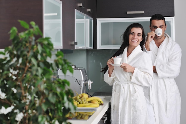 Jovem casal apaixonado tomando uma xícara de café fresco da manhã no apartamento moderno