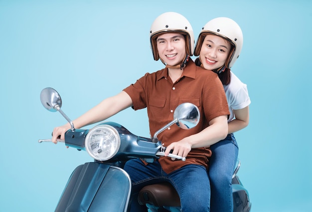 Jovem casal asiático anda de scooter no fundo