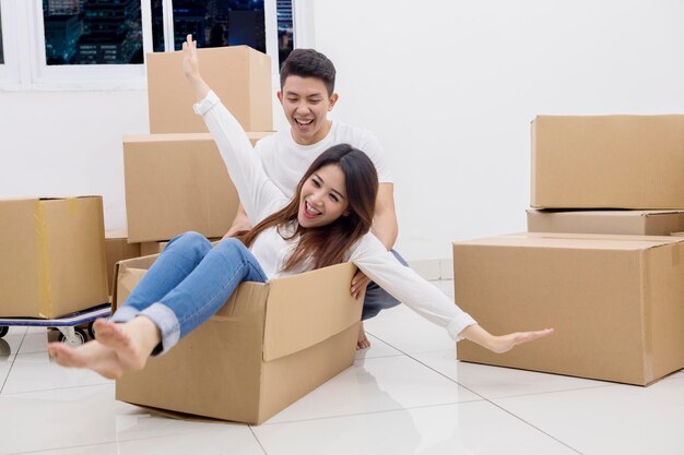 Jovem casal asiático andando em uma caixa de papelão