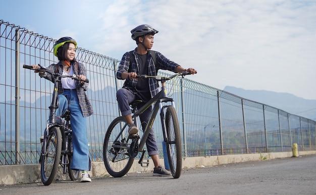 Jovem casal asiático descansando depois de andar de bicicleta vai para o trabalho