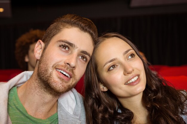 Jovem casal assistindo a um filme no cinema