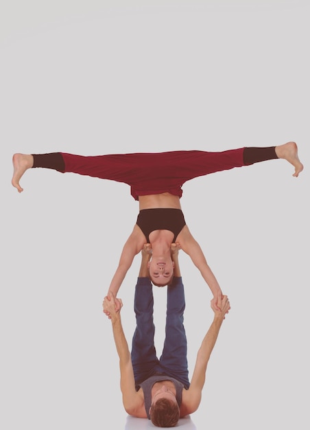 Jovem casal atlético praticando acroyoga. Equilíbrio em pares.