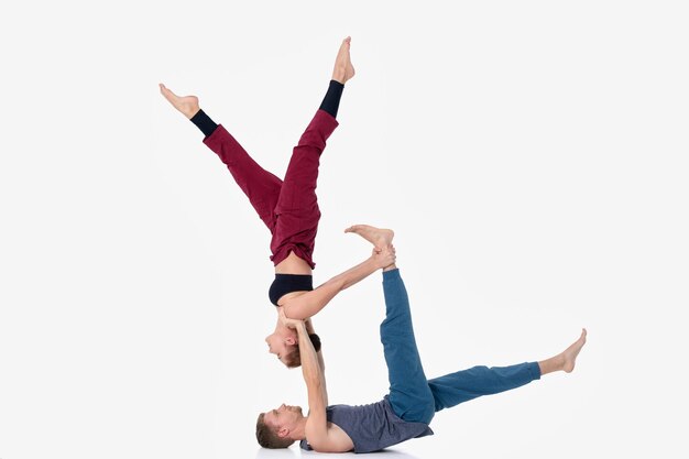 Jovem casal atlético praticando acroyoga. Equilíbrio em pares.