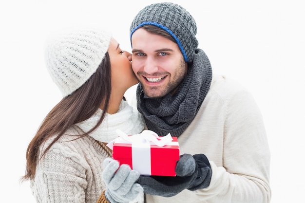 Jovem casal atraente em roupas quentes segurando presente