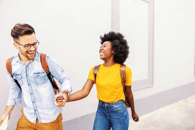 Jovem casal atraente multirracial alegre, visitando uma cidade velha. Conceito de turismo.