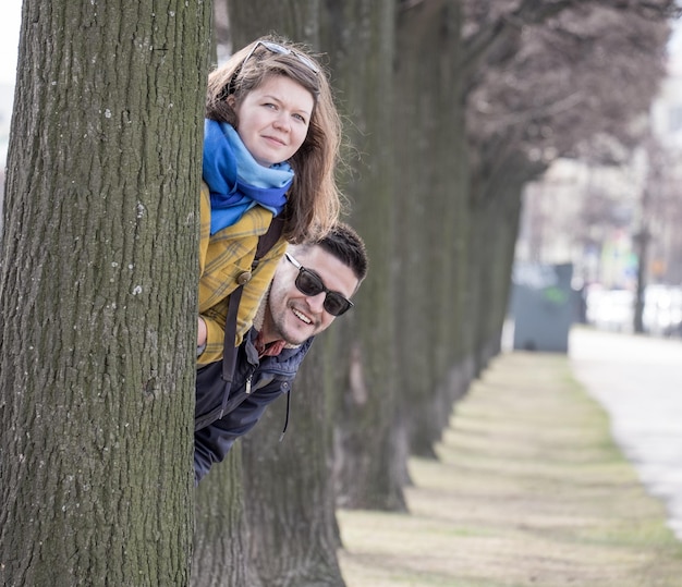 Jovem casal atrás da árvore