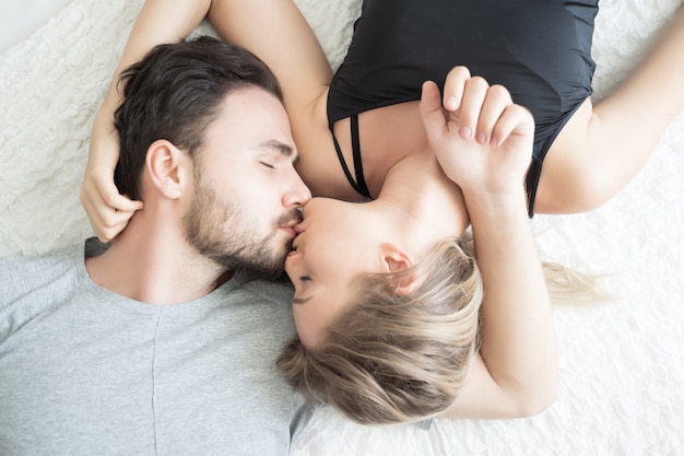 Jovem casal beijando na cama .loving casal no quarto