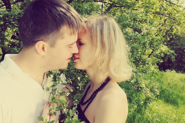 Jovem casal beijando perto do espinheiro florescendo