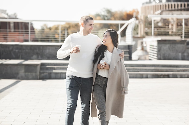 Jovem casal bonito andando no fundo da cidade. Mulher e homem juntos se divertindo no meio urbano. Adoráveis jovens namoro.