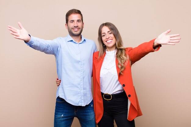 Jovem casal bonito contra parede plana bege