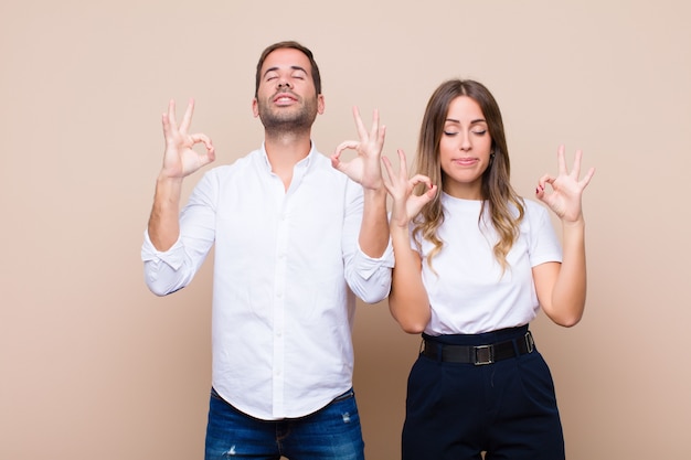 Jovem casal bonito contra parede plana bege