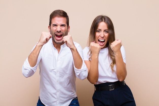 Jovem casal bonito contra parede plana bege