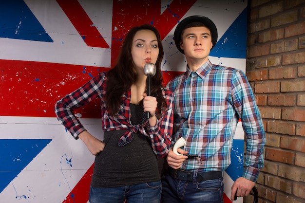 Foto jovem casal branco em roupa casual posando em frente à bandeira da grã-bretanha