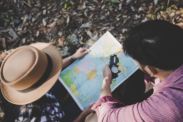 Foto jovem casal caminhantes com e olhando no mapa para encontrar uma maneira