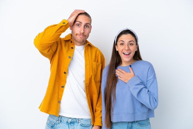 Foto jovem casal caucasiano isolado no fundo branco com expressão facial de surpresa