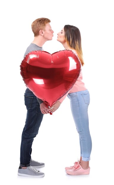 Jovem casal com balão em forma de coração no fundo branco