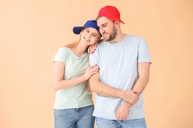 Jovem casal com bonés elegantes na cor de fundo