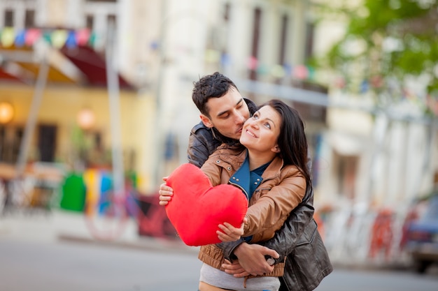 Jovem casal com brinquedo de forma de coração beijando na rua na primavera. Odessa, Ucrânia