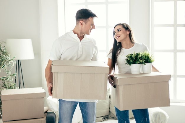 Jovem casal com caixas de papelão em um apartamento novo