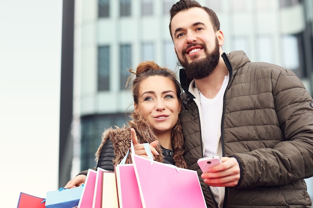 Foto jovem casal com sacolas de compras na cidade