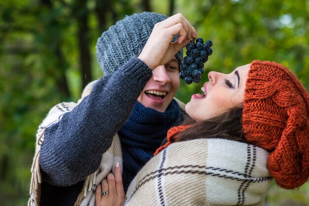 Jovem casal come uvas