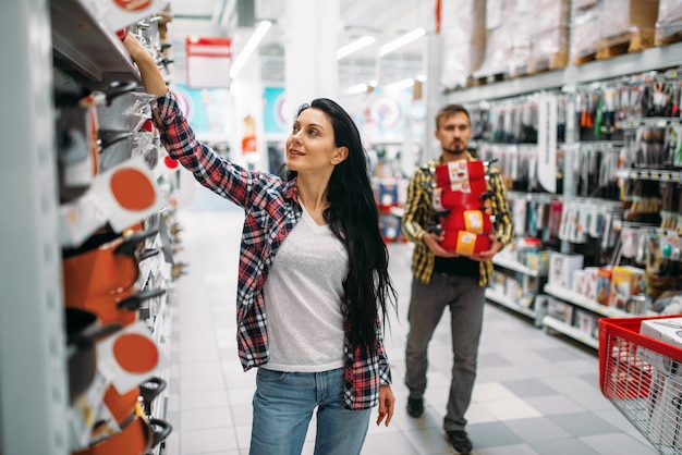 Jovem casal comprando panelas no supermercado