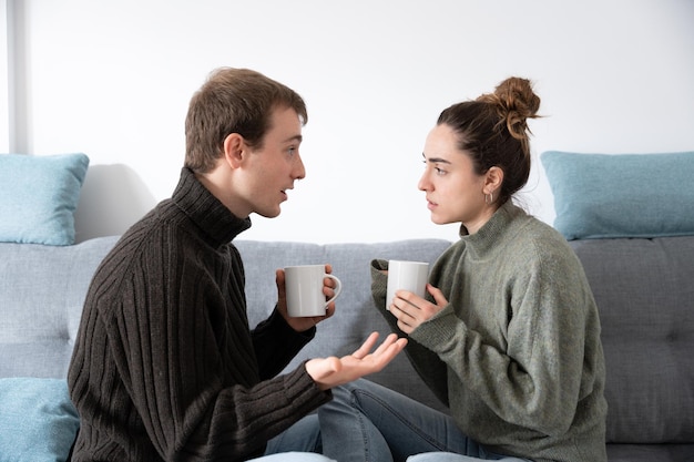 Jovem casal conversando no sofá