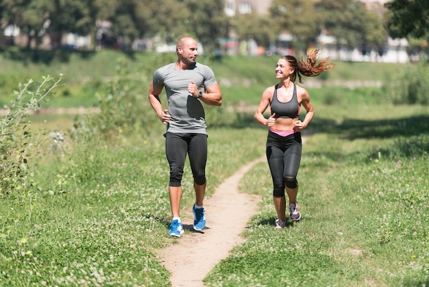 Jovem casal correndo na área de floresta arborizada treinando e exercitando para Trail Run Maratona Endurance Fitness Conceito de estilo de vida saudável