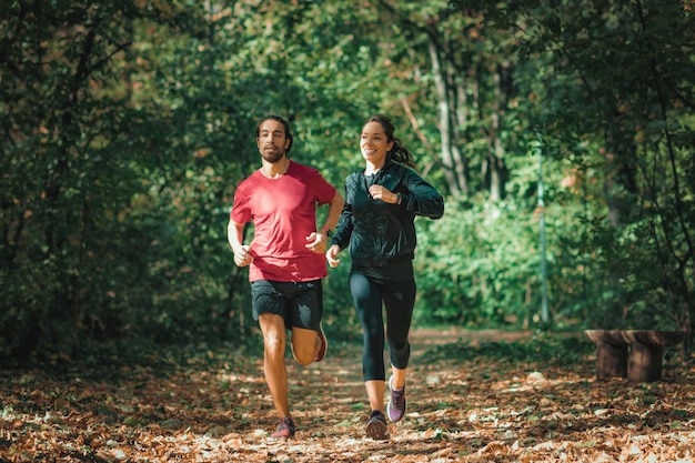 Jovem casal correndo na natureza ao ar livre