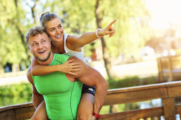 jovem casal correndo no parque no verão