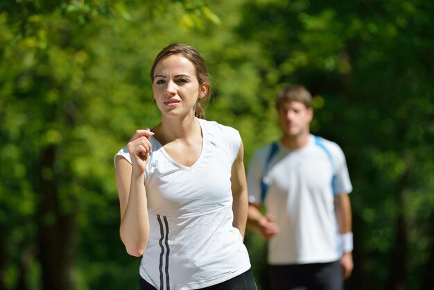 Jovem casal correndo no parque pela manhã. Conceito de saúde e fitness