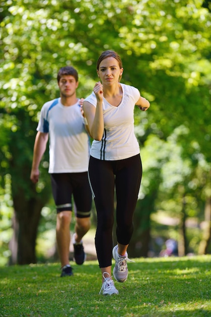 Jovem casal correndo no parque pela manhã. Conceito de saúde e fitness