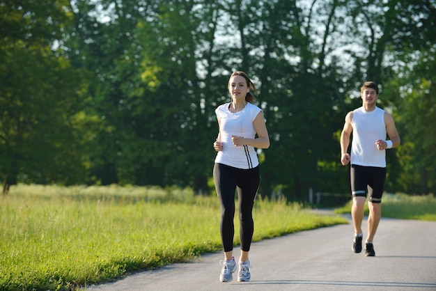 Jovem casal correndo no parque pela manhã. Conceito de saúde e fitness