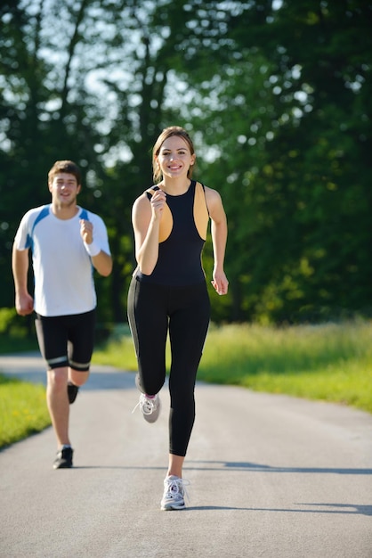 Jovem casal correndo no parque pela manhã. Conceito de saúde e fitness