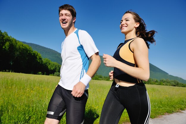 Jovem casal correndo no parque pela manhã. Saúde e fitness.