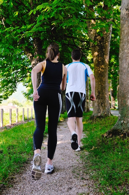 Jovem casal correndo no parque pela manhã. Saúde e fitness.