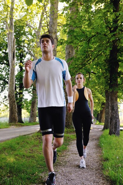 Jovem casal correndo no parque pela manhã. Saúde e fitness.