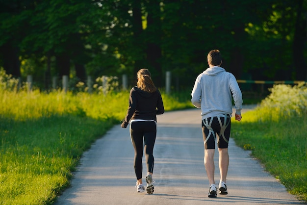 Jovem casal correndo no parque pela manhã. Saúde e fitness.