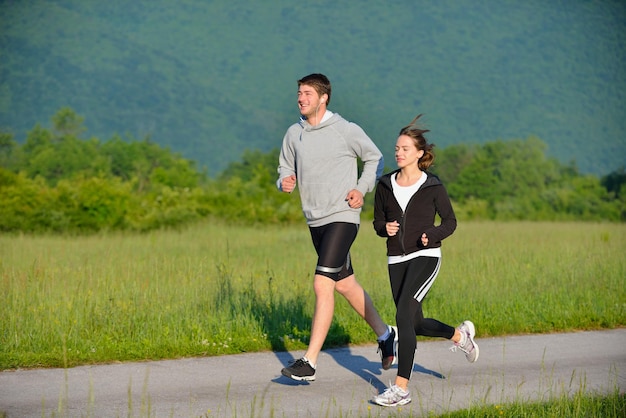 Jovem casal correndo no parque pela manhã. Saúde e fitness.