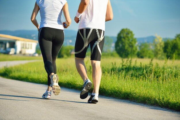 Jovem casal correndo no parque pela manhã. saúde e fitness.