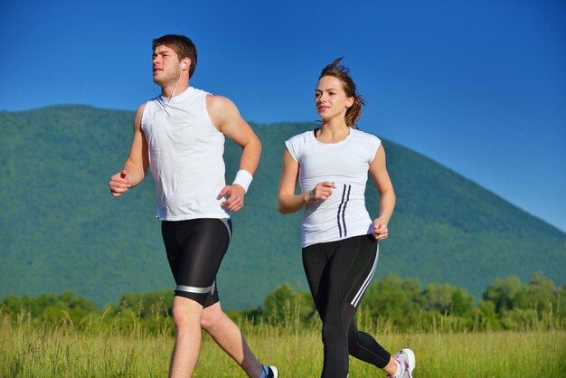 Jovem casal correndo no parque pela manhã. Saúde e fitness.