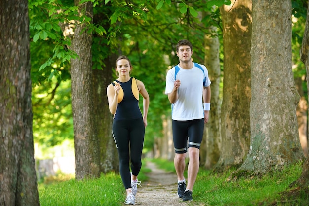 Jovem casal correndo no parque pela manhã. Saúde e fitness.