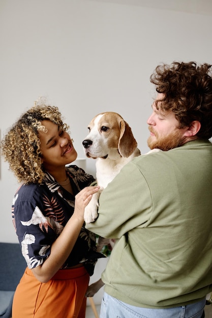 Foto jovem casal cuidando de seu cachorro